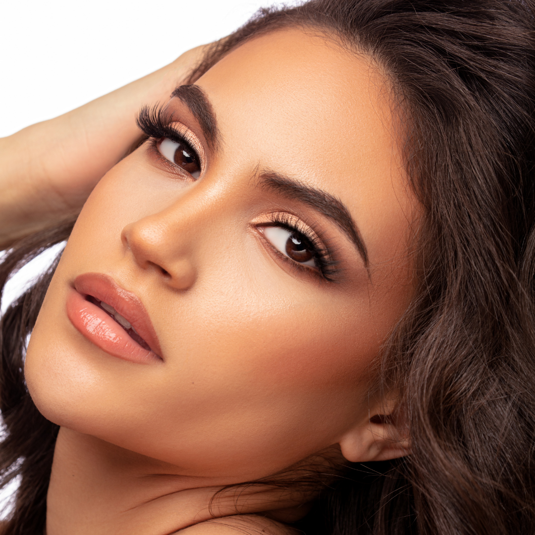 Close-up of woman with golden eyeshadow and natural makeup look