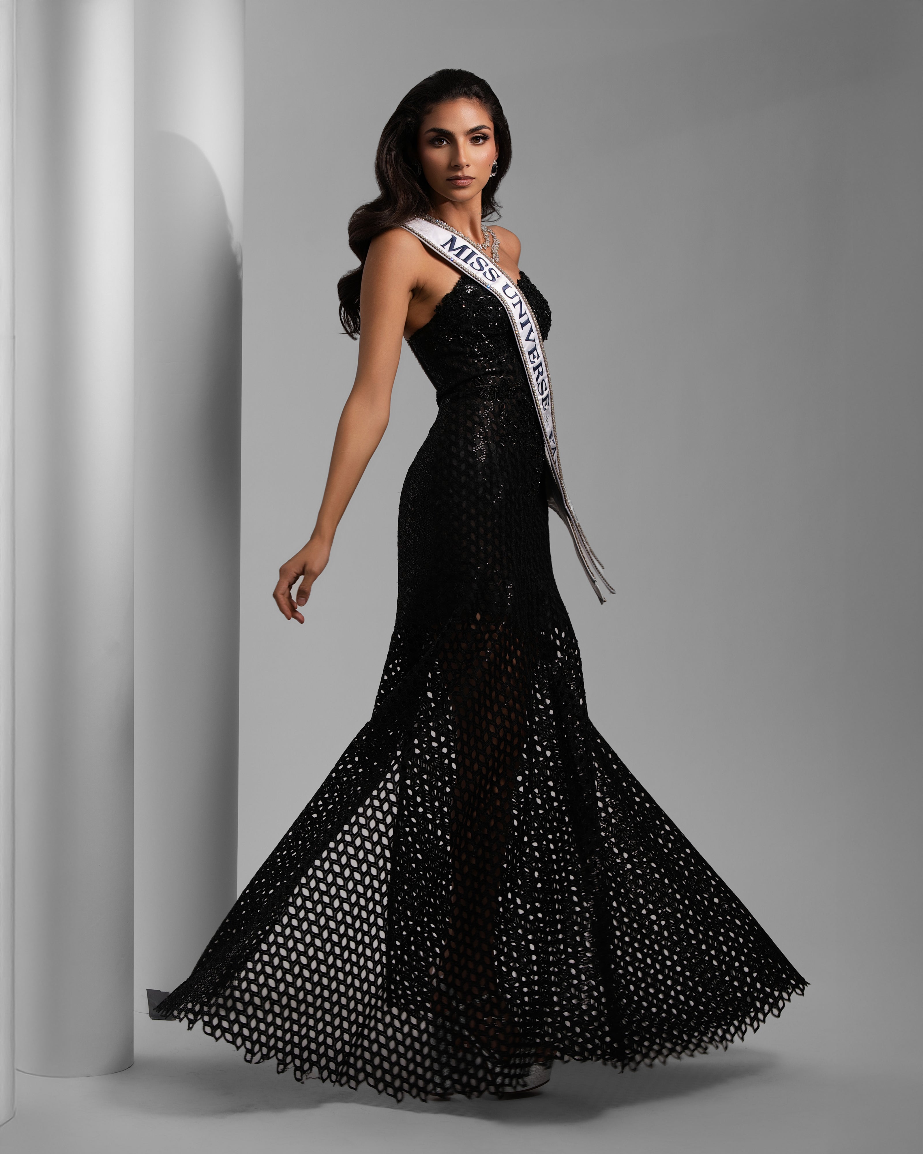 Pageant contestant in black sparkly gown with Miss Universe sash