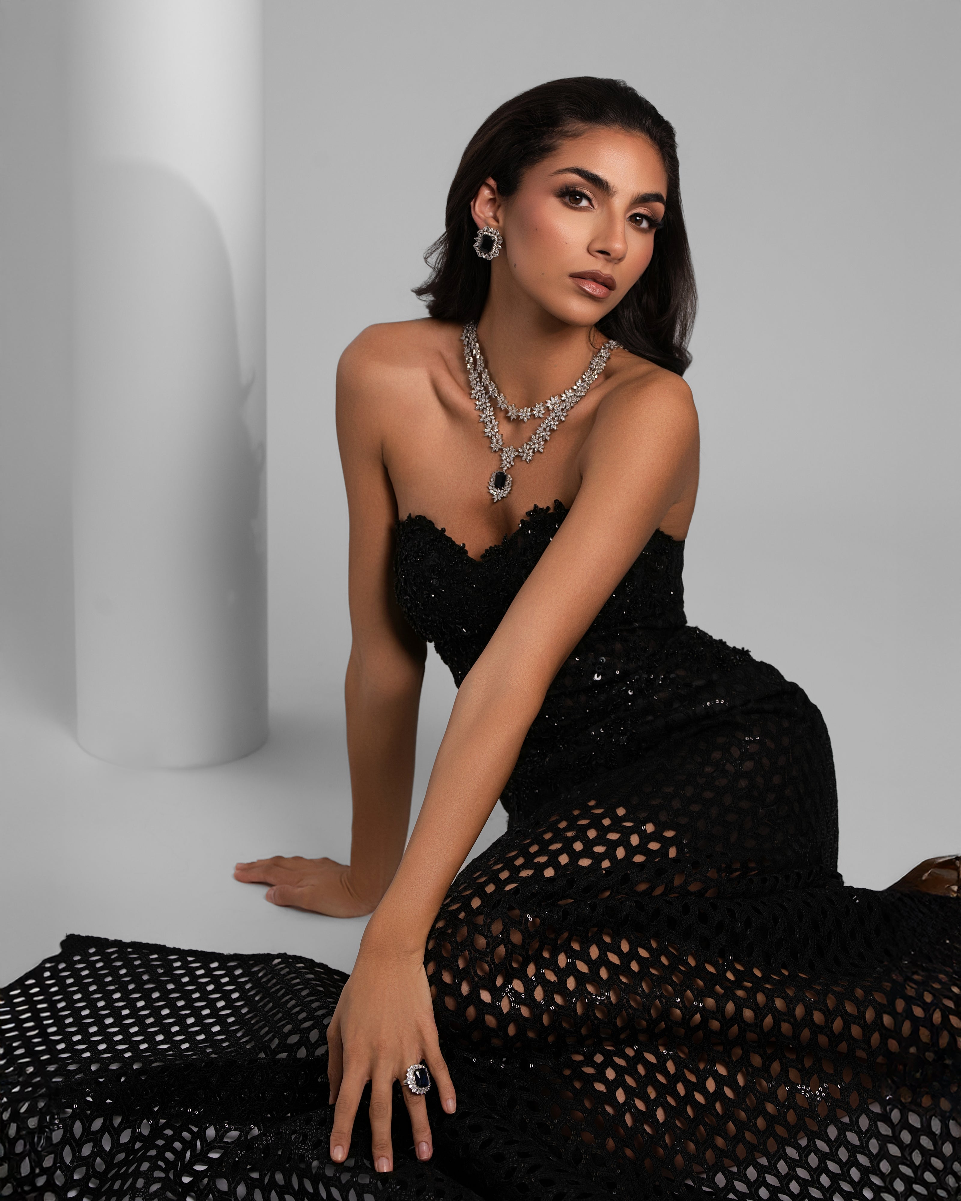 Elegant woman in black lace dress and sparkling silver jewelry