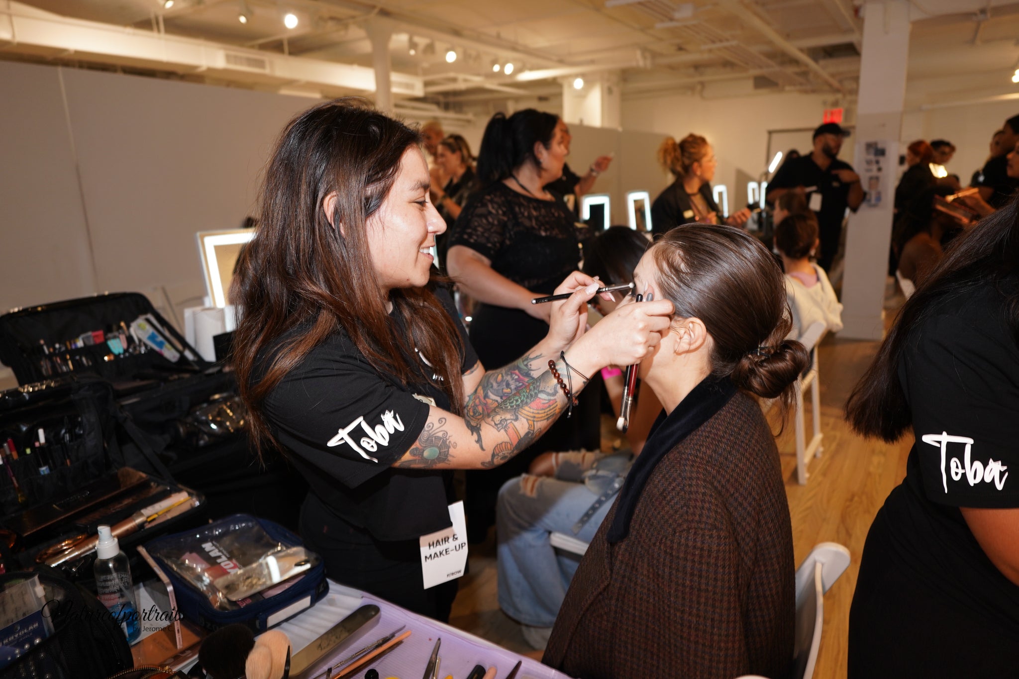 Makeup artist applying eye makeup to a client at a beauty event