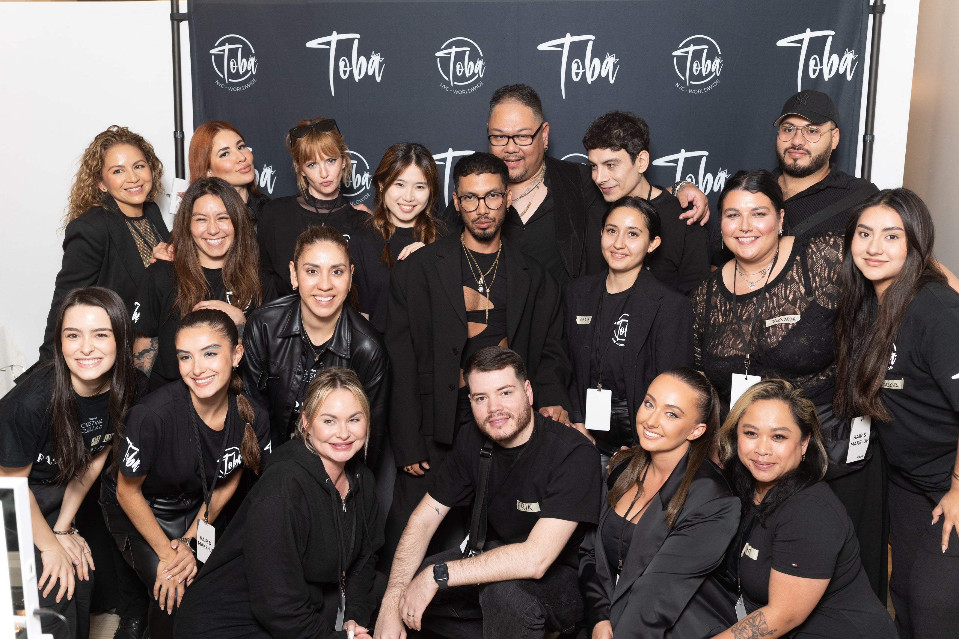 Large group photo of Toba team members posing together in black attire