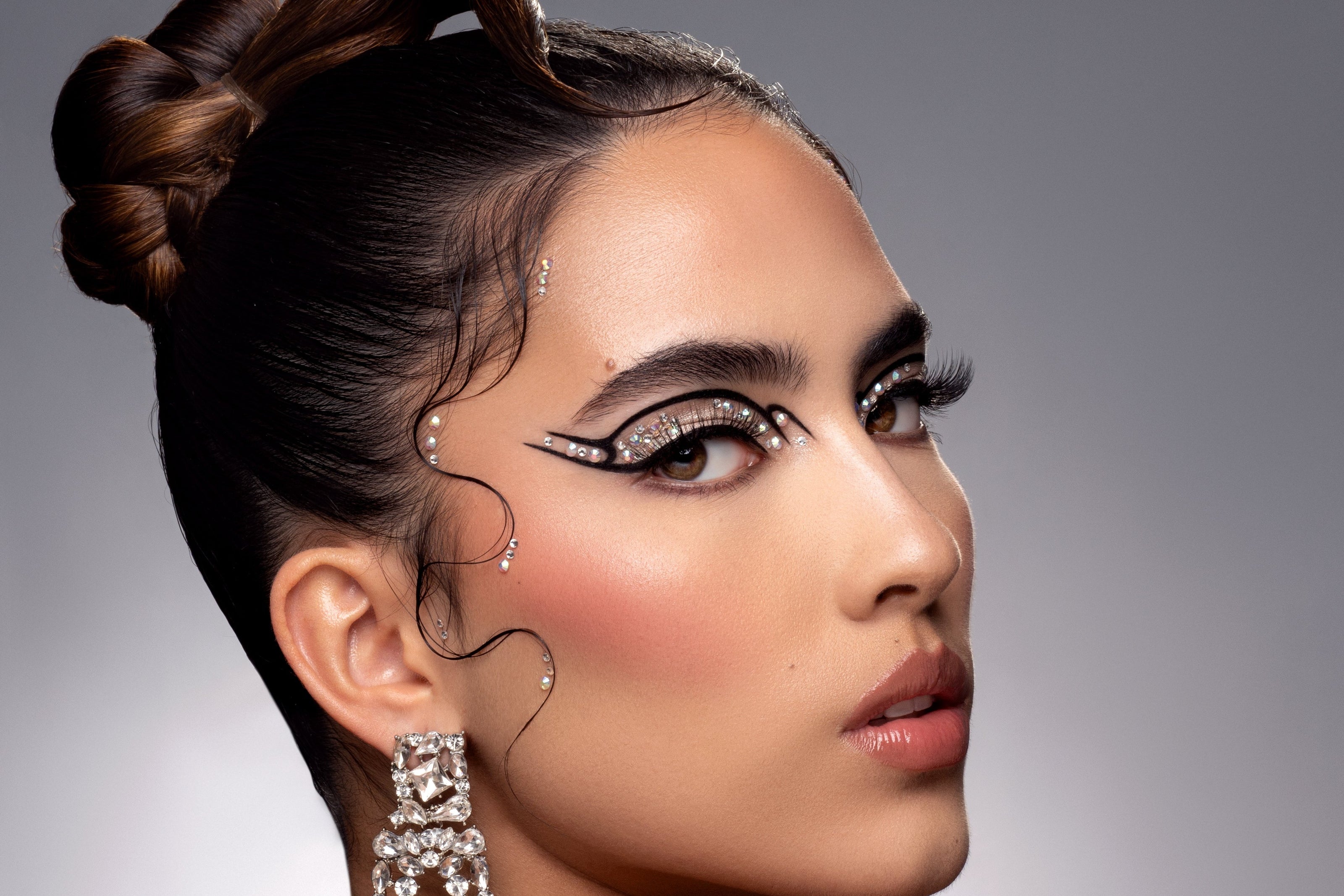 Glamorous beauty portrait with pearl-adorned eye makeup and crystal earrings